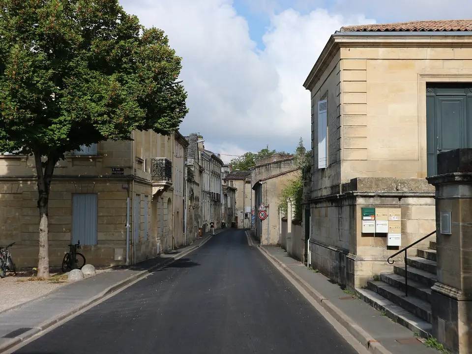 Rue André Lamandé à Blaye, bordée de maisons et de bâtiments en pierre calcaire, dont l'ancien tribunal sur la droite.